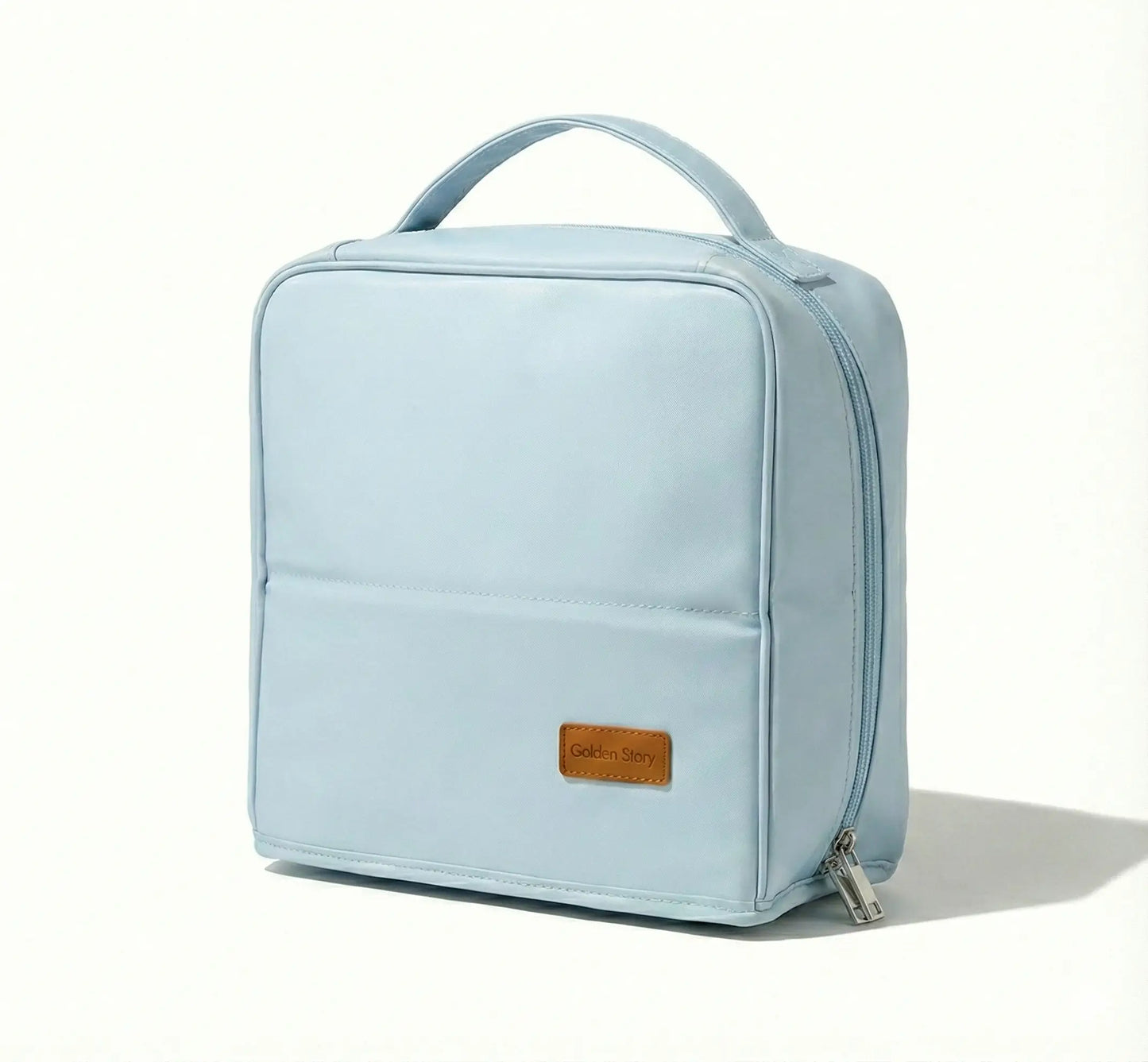 Front view of the light blue Sunday Status stand-up travel makeup bag on a clean white background, highlighting its structured square shape, top handle, and minimalist pastel design