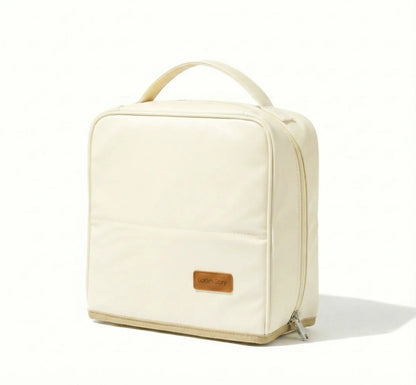 Front view of the pastel white Sunday Status stand-up travel makeup bag on a clean white background, showing its upright structured shape, smooth zipper, and convenient carrying handle