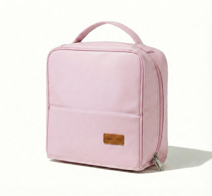Front view of the pastel pink Sunday Status stand-up travel makeup bag on a clean white background, showcasing its structured square shape and convenient top handle