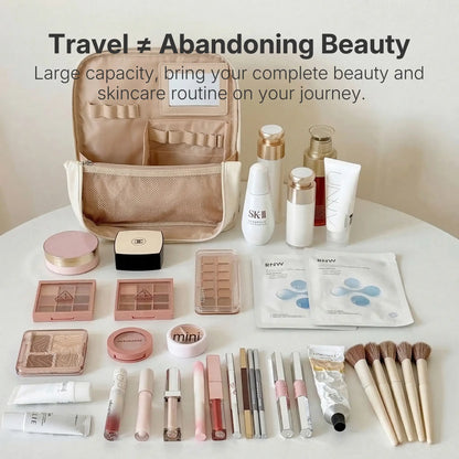 An open white Sunday Status stand-up travel makeup bag displayed on a luxurious golden silk background. It is surrounded by a perfectly organized flatlay of cosmetics, including dozens of makeup brushes, lipsticks, palettes, and full-sized skincare bottles, showcasing its massive packing capacity